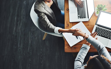 Poster - Lets merge our talents as we get to the top. High angle shot of two businesswomen shaking hands in an office.