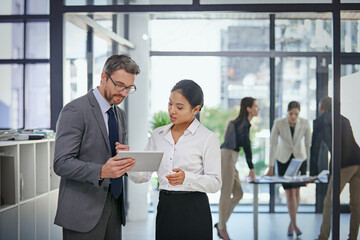 Poster - This app is going to streamline our internal communication. Shot of a businessman showing something to his female colleague while they stand outside the boardroom.