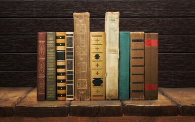 Stack of old worn shabby books in leather binding in the dark.