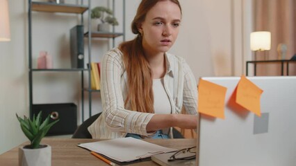 Exhausted woman freelancer using laptop computer with sticker notes on it having concentration problem, creative crisis. Nervous adult girl confused by big routine work loading indoors at home office