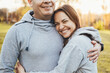 © Strelciuc - A caucasian middle-aged couple posing while hugging in a park. Concept relations. Family lifestyle concept. Family day.