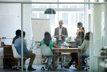 Poster - He has their full attention. Shot of a group of coworkers in a boardroom meeting.
