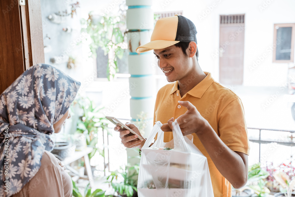 Phone For Delivery Deliveryman holding a cell phone while delivering vegetable orders ...