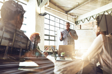 This is the great big plan. Multiple exposure shot of businesspeople having a meeting superimposed over a cityscape.