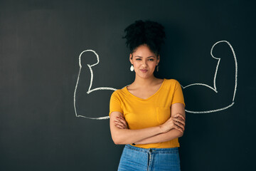 i am a strong woman. shot of a woman posing with a chalk illustration of flexing muscles against a d