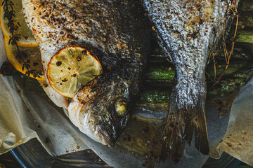Wall Mural - Two dorado fish with lemons and asparagus. The concept of a delicious and healthy dinner for two.
