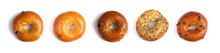 A Row Of Five Different Types Of Bagels Isolated On A White Background
