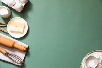 Frame of food ingredients for baking on a green pastel background. Cooking flat lay with copy space. Top view. Baking concept. Mockup.