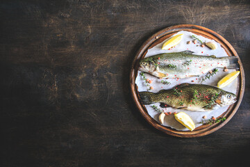 Wall Mural - two raw rainbow trouts on paper with thyme and lemon. Fish trout. Top view. Free space for your text.