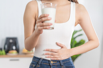 pain, allergy asian young woman, girl hand in belly suffer after drink glass of milk, unhappy and ba