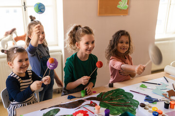 Wall Mural - Group of little kids working on project during creative art and craft class at school.