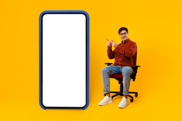 Poster - Man Pointing Fingers At Big Smartphone Screen Sitting, Yellow Background