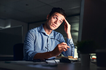 Fototapete - Whatever comes my way, I will still complete the deadline. Cropped shot of a young attractive businessman working late in the office.