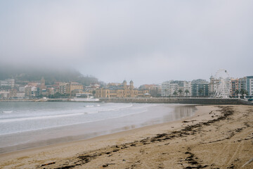 Wall Mural - A beautiful shot of beach in the background of a cityscape in foggy weather.