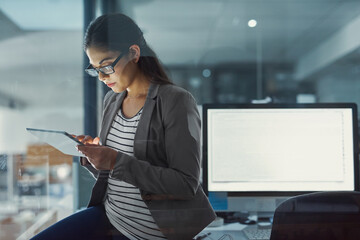 Poster - checking companies stats from my device. shot of a young businesswoman working late in the office.