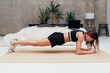 © undrey - Woman doing the plank exercise at home
