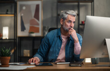 Mature Man Architect Working On Computer At Desk Indoors In Office.