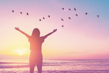 Wall Mural - Copy space of woman raise hand up on sunset sky at beach and island background.