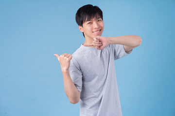 Young Asian man posing on blue background