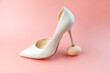 © Alexandr Milodan - A woman's white shoe stands with a heel on a chicken egg. Concept photo.