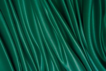 Wall Mural - Beautiful elegant wavy dark green satin silk luxury cloth fabric with monochrome background design. Wallpaper, banner. Copy space.
