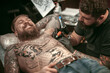 © Mr. Prof - Professional tattooist does tattoo on the skin of his client in the salon