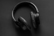 © Yevhenii Rukavitsyn - Black wireless headphones on a black background