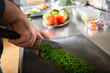 © ADDICTIVE STOCK - Unrecognizable cook chopping fresh herbs