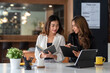 © amnaj - Teamwork process. Two Asian businesswoman working pointing laptop computer and discussing documents and idea at meeting.