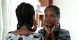 © Marco - Teenager black girl looking at herself in mirror. Adolescent african girl inspecting face