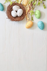 Wall Mural - branches with green leaves and easter eggs on a light background. happy easter flat lay concept