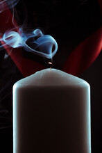 Candle With Blue Smoke On Black Background

