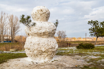 Wall Mural - Huge spring snowman in melted meadow. Background with copy space for lettering or text