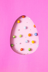 Wall Mural - Chocolate easter eggs and decor flat lay for kids easter hunt egg concept on pink background. Sweets in the shape of an egg