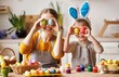 © JenkoAtaman - Happy mother and little son sitting at table in kitchen and covering eyes with Easter eggs