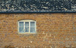 Sandstone stone building wall. House with a window. Rough grainy stone texture background