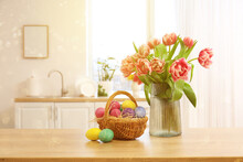 Basket With Easter Eggs And Vase With Tulips On Table In Kitchen
