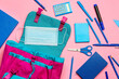 © Pixel-Shot - Backpack with different stationery and medical mask on pink background