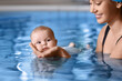 © Pixel-Shot - Swimming coach and adorable baby in pool