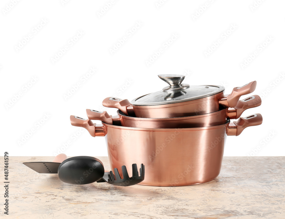Set of copper kitchen utensils on table against white background