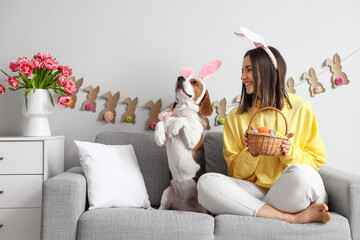 Wall Mural - Young woman and cute Beagle dog celebrating Easter at home