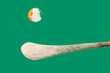 Minimal GAA Irish sport concept. Traditional Ireland gaelic sports stick hurleys with fluffy Irish tricolore balls above it. Green background