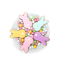 Wall Mural - Plate with delicious Easter cookies in shape of bunny and candies on white background