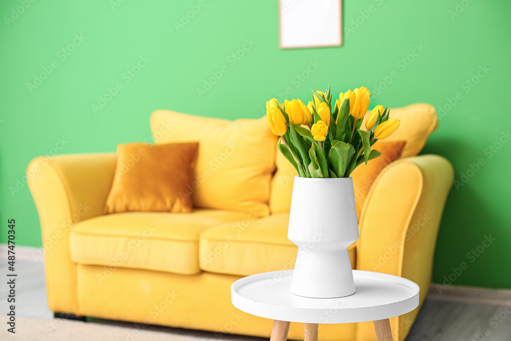 Vase with beautiful tulips on table in room interior