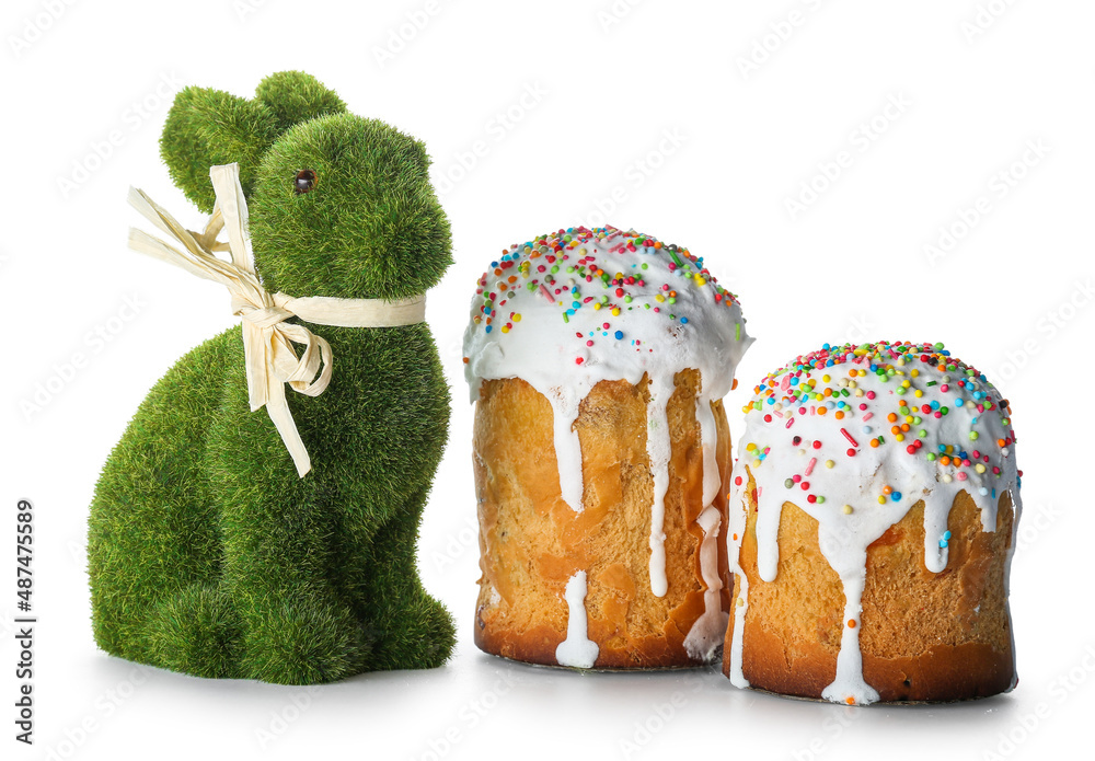 Cute Easter bunny and cakes on white background