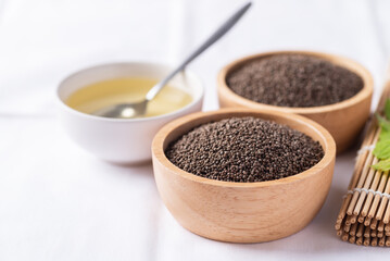 Wall Mural - Perilla oil and seeds in bowl on white background, Healthy herbal seed ingredients in Asian food