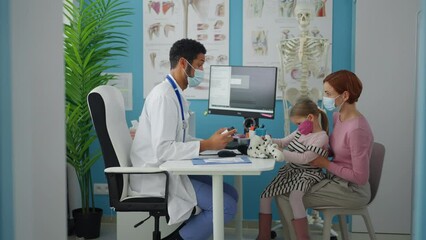 Wall Mural - little girl with her mother at doctor's office on consultation, coronavirus concept.