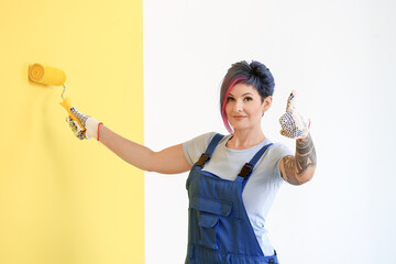 Sticker - Female decorator painting yellow wall and showing thumb-up in room