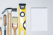© Sergey - Different construction tools and notebook on grey surface.  building tools, construction buildings, repair concept.