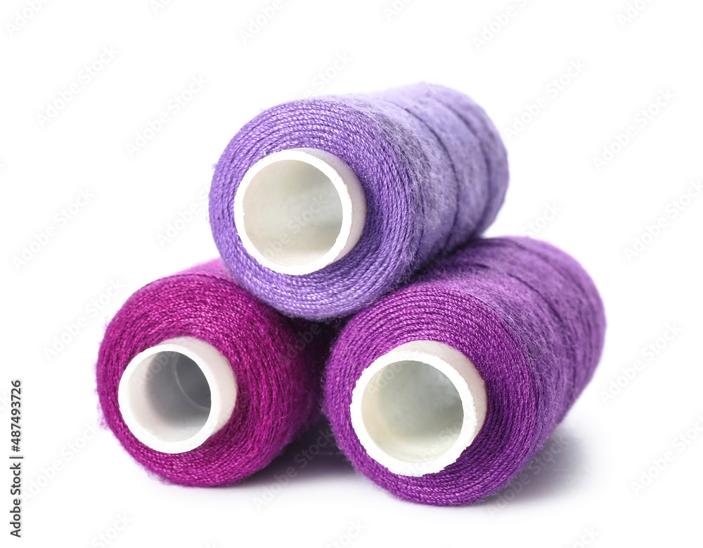Purple sewing threads on white background